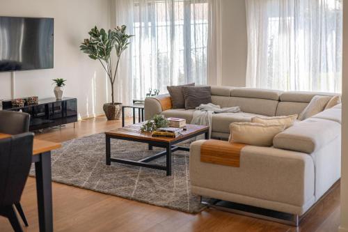 a living room with a couch and a table at StayAU Cozy Holiday House 4BRM Big Group Tarneit in Tarneit