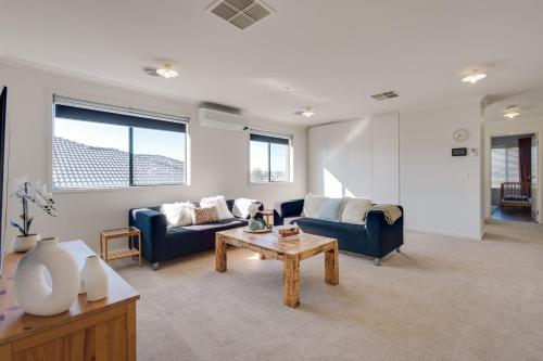 a living room with two blue couches and a coffee table at StayAU Cozy Holiday House 4BRM Big Group Tarneit in Tarneit