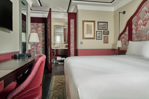 a bedroom with a bed and a desk with chairs at Maxwell Reserve Singapore, Autograph Collection in Singapore