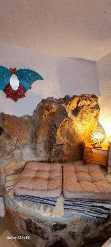 a bedroom with two beds in a rock wall at Villa Sarichel in Nikithianós