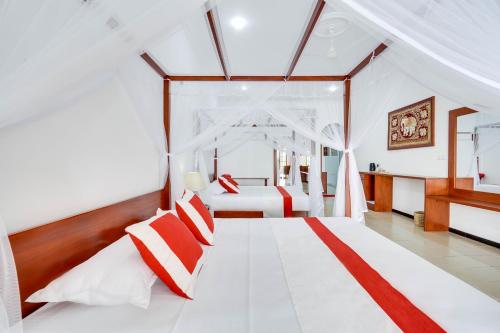 a bedroom with a white bed with red and white pillows at Treetop Resort By Scenery Villas in Dharga Town