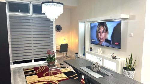 a living room with a flat screen tv on a wall at LIGUANEA -ONE BEDROOM OASIS near US EMBASSY in Barbican