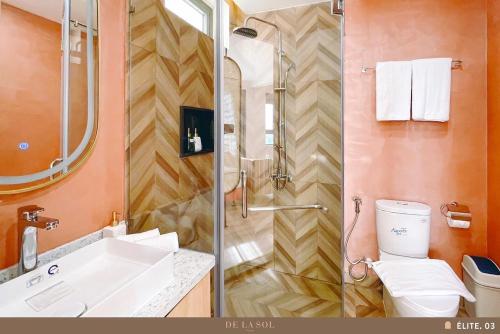 a bathroom with a shower and a sink and a toilet at De La Sol Villa Dalat in Da Lat