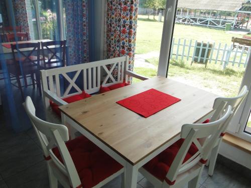 a wooden table with chairs and a red napkin on it at Wioska pod Kogutem in Krępa