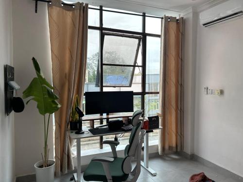 Cette chambre dispose d'une fenêtre et d'un bureau avec un ordinateur. dans l'établissement Amaan, à Dar es Salaam