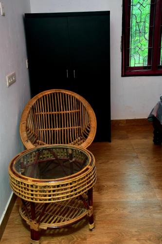 a wicker chair sitting in front of a door at Paradise Quest Nature Farmhouse in Kālapettai