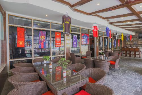 a restaurant with tables and chairs and signs on the windows at Hotel Crown Plaza in Kathmandu