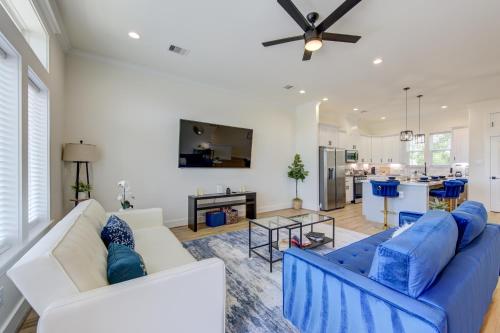 a living room with a blue couch and a kitchen at Exquisite House with rooftop in Houston in Houston