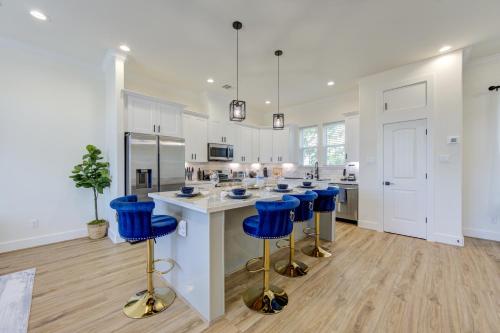 a white kitchen with blue bar stools and a counter at Exquisite House with rooftop in Houston in Houston