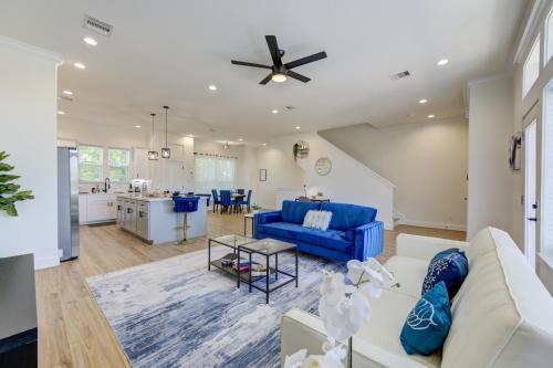 a living room with a blue couch and a kitchen at Exquisite House with rooftop in Houston in Houston