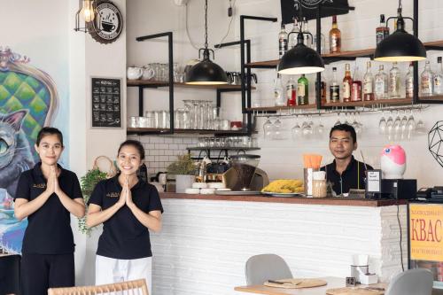 a group of people standing in a restaurant with their hands in front at Kata Station Boutique Hotel in Kata Beach