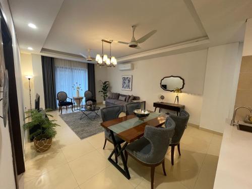 a dining room and living room with a table and chairs at 1 Bedroom Furnished Apartment at Eighteen Islamabad in Islamabad