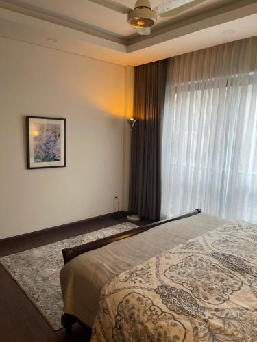 a bedroom with a bed and a window at 1 Bedroom Furnished Apartment at Eighteen Islamabad in Islamabad
