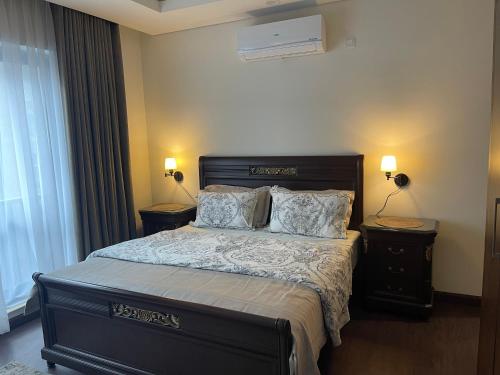 a bedroom with a large bed with two night stands at 1 Bedroom Furnished Apartment at Eighteen Islamabad in Islamabad