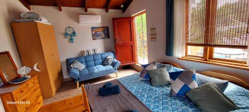 Villa Sarichel في Nikithianós: غرفة معيشة مع أريكة زرقاء وطاولة