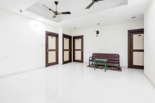 a room with a bench and a ceiling fan at OYO HOTEL SHOOLIN in Indore