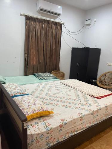 a bed with a quilt on it in a room at Paradise Quest Nature Farmhouse in Kālapettai
