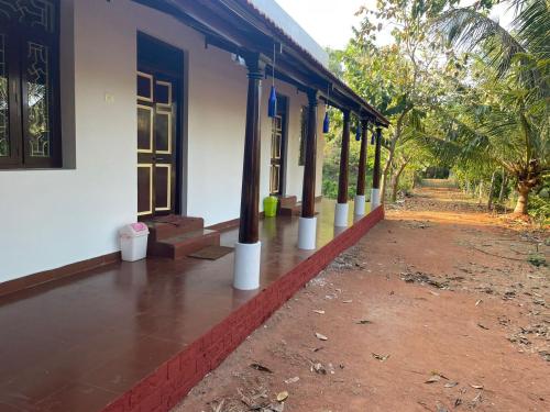 a building with columns on the side of it at Paradise Quest Nature Farmhouse in Kālapettai