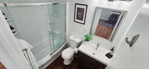 y baño con ducha, aseo y lavamanos. en Walk to Everything From The Lofts Suite 307, en West Palm Beach