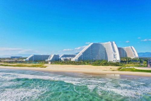 Arena Apart-Resort Cam Ranh with Ocean view-Private beach في كام رنه: اطلالة على شاطئ يوجد مباني في الخلف