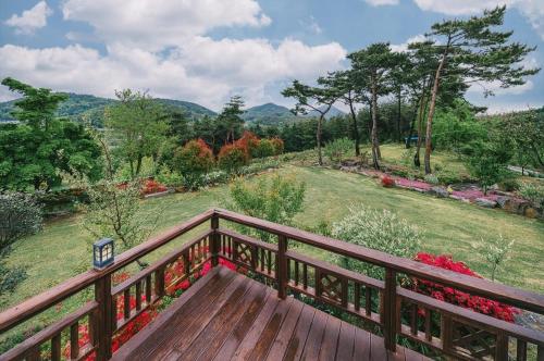 a wooden deck with a view of a field at Yeosu Hanulchaeok Pension in Yeosu