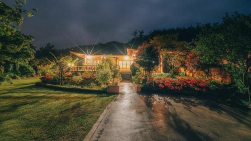 a house with a driveway in front of a yard at Yeosu Hanulchaeok Pension in Yeosu