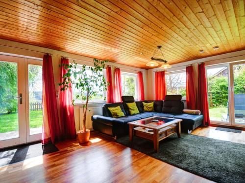 フェルトベルクにあるHoliday home Black Forestのリビングルーム(青いソファ、赤いカーテン付)