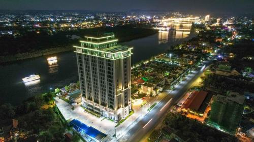 un palazzo alto con luci su una città di notte di Castle Bayview Resort & Spa a Kampot
