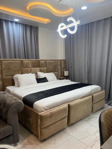 a bedroom with a large bed and a chandelier at HighX Hotels in Port Harcourt
