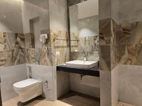 La salle de bains est pourvue de toilettes, d'un lavabo et d'un miroir. dans l'établissement Lifestyle studios, à Gurgaon