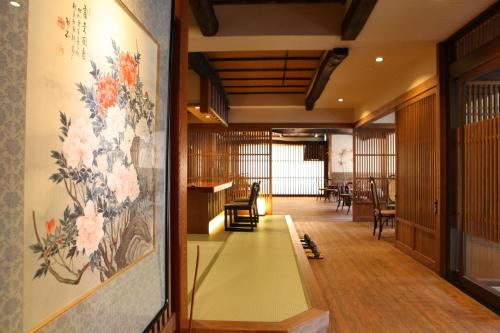 a hallway with a painting of flowers on the wall at 志賀高原 白い温泉 渓谷の湯 in Yamanouchi