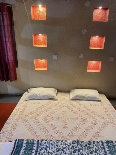 a bedroom with a bed with two pillows on it at Paradise Quest Nature Farmhouse in Kālapettai
