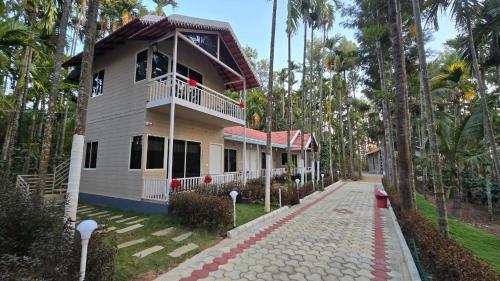 a house with a walkway in front of it at Areca ranches home stay in Chikmagalūr