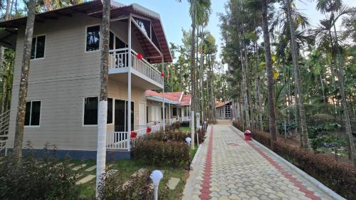 a house with a walkway next to a building at Areca ranches home stay in Chikmagalūr