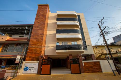 um edifício alto com uma varanda numa rua em MUGUNDAN 'S SMART STAY em Coimbatore