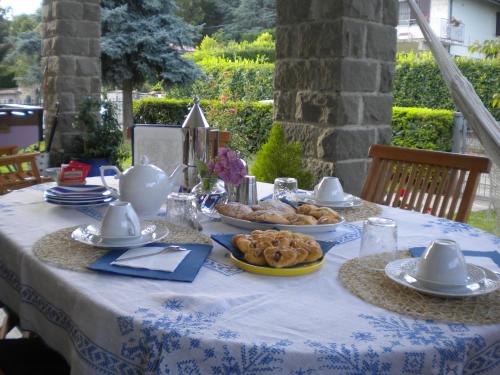 una mesa con un mantel azul y blanco con comida. en B&B Serra Pineta, en Serramazzoni