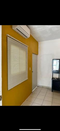 a room with a window and a yellow wall at LOP’z in Altamira