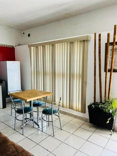 a table and chairs in a room with vertical blinds at LOP’z in Altamira
