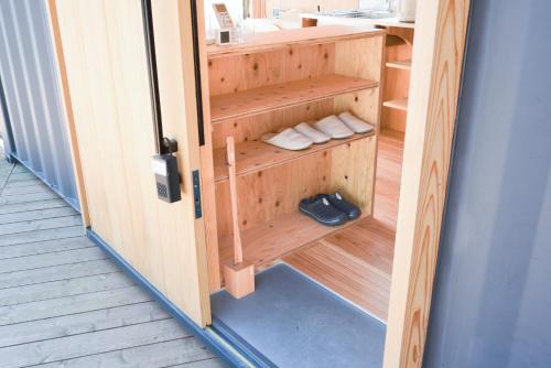 a door to a sauna with towels and shoes in it at 安全第一 客室　コンテナハウス in Nishiawakura