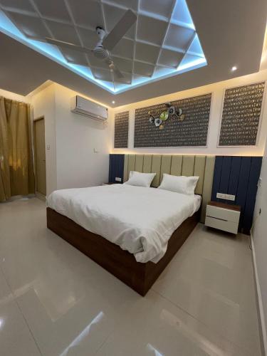 1 dormitorio con 1 cama con techo azul en SNR VENUS HOTELS, en Tirupati