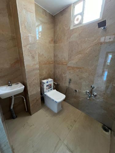 a bathroom with a toilet and a sink at SNR VENUS HOTELS in Tirupati