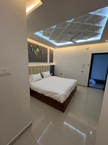 1 dormitorio con 1 cama y techo azul en SNR VENUS HOTELS, en Tirupati