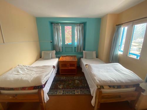 Namche的住宿－Himalayan lodge and Restuarant，客房设有两张单人床和一扇窗户。