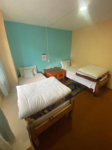 um quarto com duas camas e uma mesa-de-cabeceira e sidx sidx sidx em Himalayan lodge and Restuarant em Namche