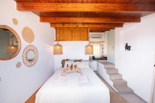 um quarto com uma cama branca e uma escada em Alfa Loft (by Lemon Tree Houses) em Vrachati