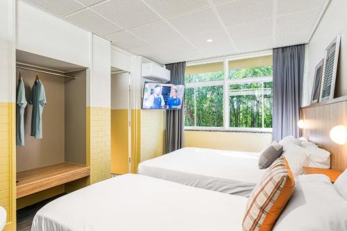 ein Hotelzimmer mit 2 Betten und einem TV in der Unterkunft Brighton Hotel in Brighton