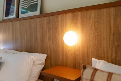 a bedroom with a bed and a light on the wall at Brighton Hotel in Brighton