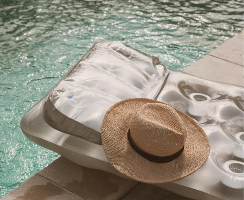 um chapéu sentado numa jangada ao lado de uma piscina em Résidence Casamea, charmant T2 em Talasani