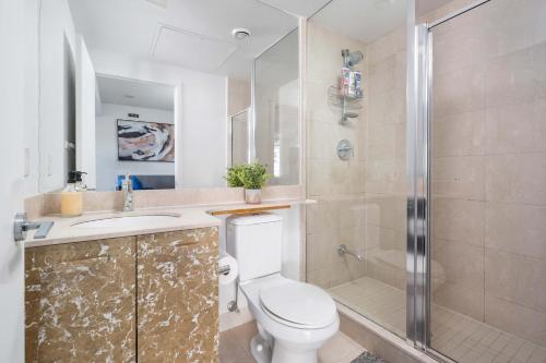 e bagno con servizi igienici, lavandino e doccia. di Spacious 2BR+2BA w/ 4 Beds Near Yorkville! a Toronto