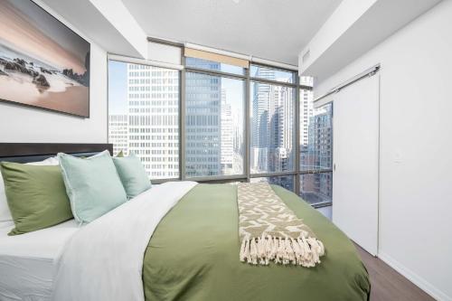 ein Schlafzimmer mit einem großen Bett und einem großen Fenster in der Unterkunft Spacious 2BR+2BA w/ 4 Beds Near Yorkville! in Toronto